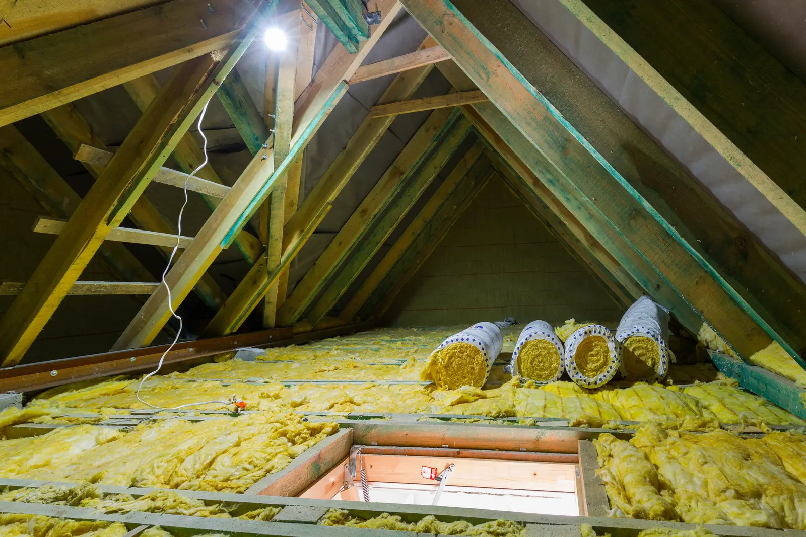 Loft insulation rolls stored in attic roof space